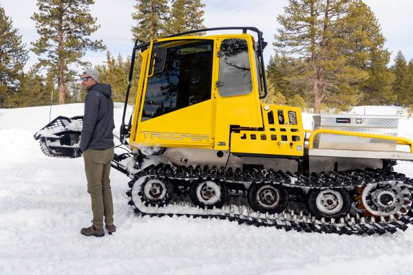 Director of Golf, Travis Alley, who hired the snowcat, supervises the work.