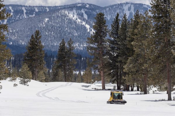 Snowcat drives up the 18th fairway with Northstar California in the background